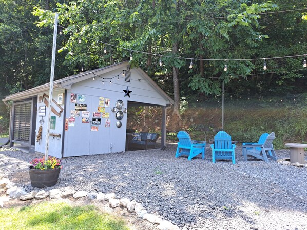 A small shed with a star decoration, surrounded by blue Adirondack chairs, and a gravel area with a flower pot. - 3 BR house with hot tub near Lexington and surrounding attractions! (Glasgow)