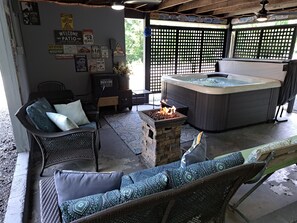 A patio area with a hot tub, wicker furniture, and a fire feature. - 3 BR house with hot tub near Lexington and surrounding attractions! (Glasgow)