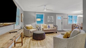 A living room with a sofa, armchairs, a coffee table, and a TV. - Coastal Soul House in the heart of Naples (Naples)