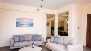 A living room with two sofas, a coffee table, and a painting on the wall.