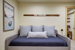 Ein Schlafzimmer mit Bett, Kissen, einem an der Wand befestigten Schild und einem Poster.