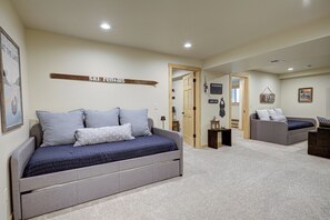 Ein Schlafzimmer mit Bett, einer Couch und einem Flur, der in einen anderen Raum führt.