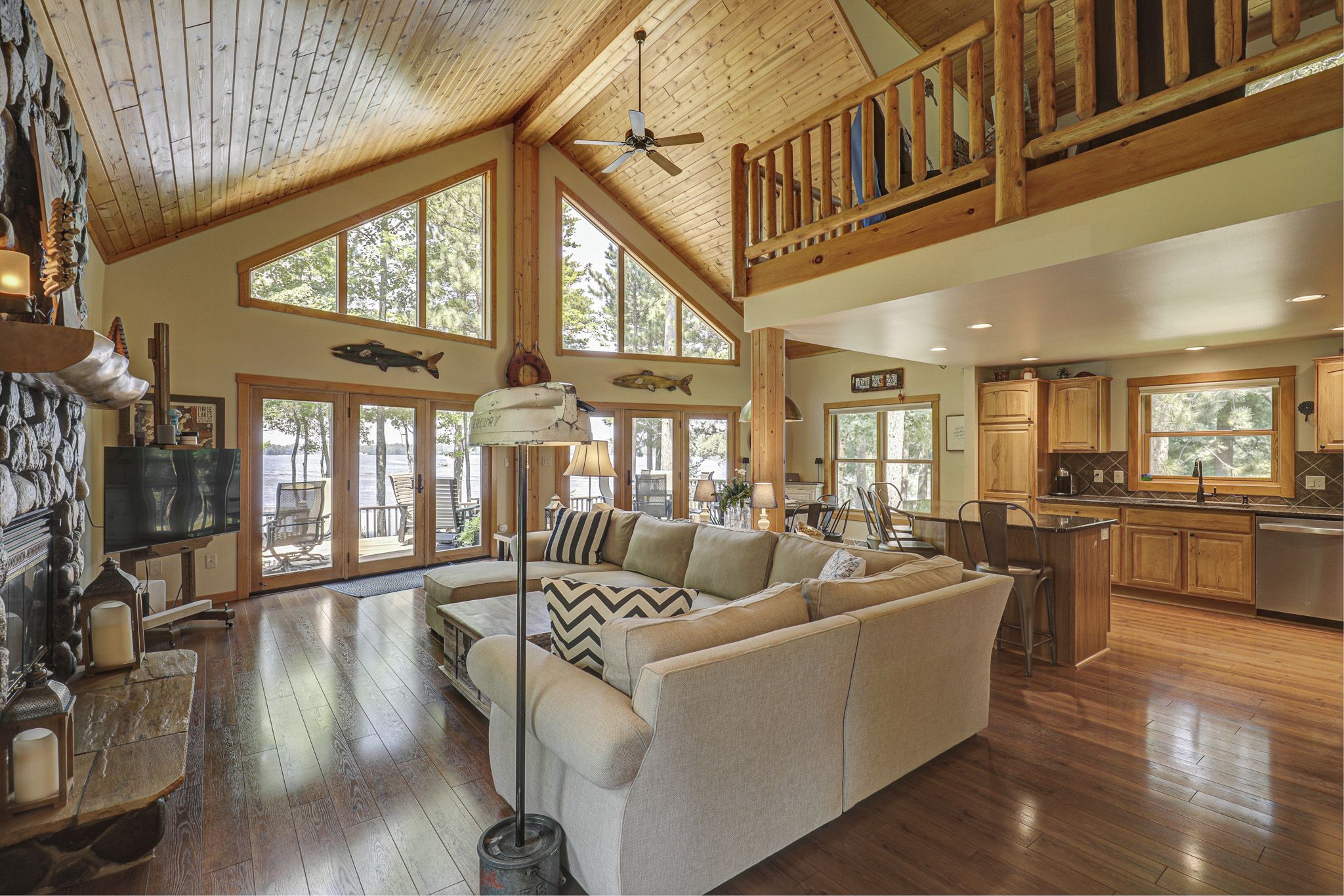 A spacious living area with a large sofa, wooden flooring, and a view of the outdoors.