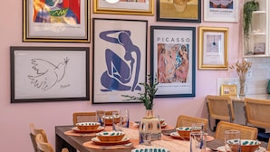 A dining area with a wooden table set for four, surrounded by chairs with patterned upholstery. - ★Hot tub under the stars★ 4-King Beds, Cowboy Pool, Game Room, Fire Pit, JTNP (Twentynine Palms)