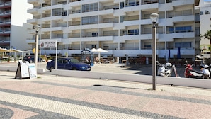 A multi-story hotel with balconies, a central courtyard, and outdoor seating areas. - T1 Praiamar 4E A C FR MAR Garagem (Loulé)