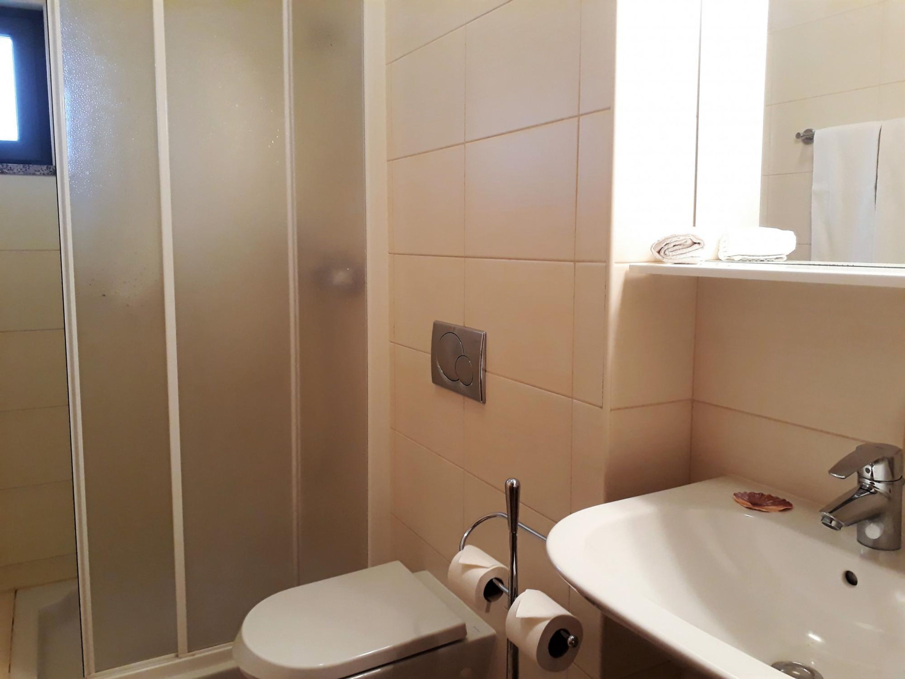 A bathroom with a toilet, a sink, and a shower.