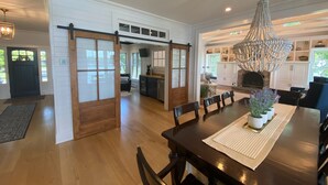 A spacious dining area with a wooden table, chairs, and a chandelier. - Spectacular Riverfront Property (Manasquan)