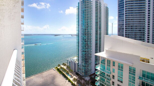 A high-rise hotel with a view of the ocean and a beach.