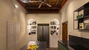 Une cuisine moderne dotée d’un îlot central, d’appareils électroménagers intégrés et d’un ventilateur de plafond.