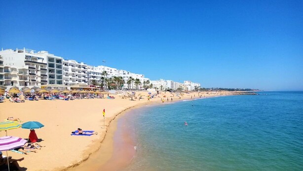 A sandy beach with clear blue water, umbrellas, and beachgoers. - T1 Pontemira 5 F- A C 50M Praia TV Wifi (Loul é)