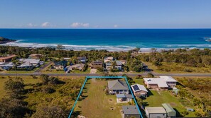 Stunning ocean views surround homes in this coastal neighborhood, nestled among lush greenery and paved roads.