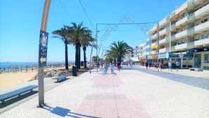 A beach promenade with palm trees, benches, and a clear view of the sea. - T0 A C Varandas Mar 3 B Perto Praia Wi-fi (Loulé)