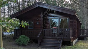 Una cabaña de madera con un porche, una pequeña escalera y un letrero que dice "Pine Ridge".