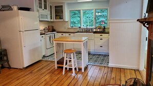 A compact kitchen with white cabinets, a wooden countertop, and a window overlooking greenery. - New Elk Mtn Listing: Cozy family ski house -- 2 min from Elk! (Union Dale)