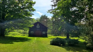 A rustic wooden house surrounded by lush greenery and trees. - New Elk Mtn Listing: Cozy family ski house -- 2 min from Elk! (Union Dale)