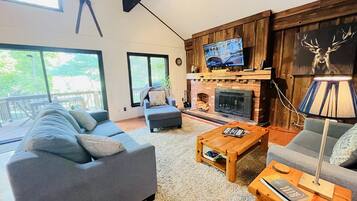 Smart-tv, een open haard, boeken en een printer