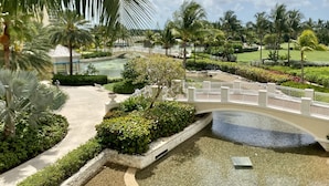 A resort with a bridge over a water feature, surrounded by lush greenery and palm trees. - Spacious 3-Bedroom Apartment with WiFi & AC in Lovely Nassau (Nassau)
