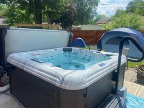 Relax in the backyard hot tub with a seat and control panel.