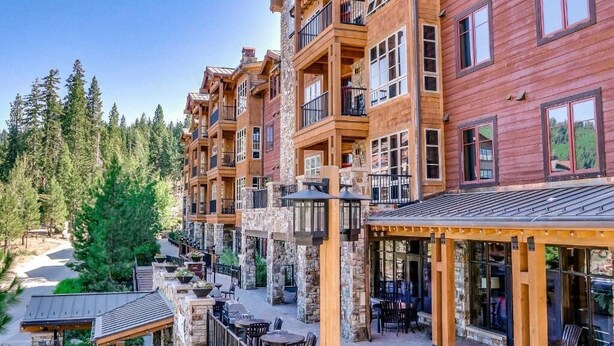 Un immeuble en bois à plusieurs étages, doté de balcons et d’espaces de détente en plein air.