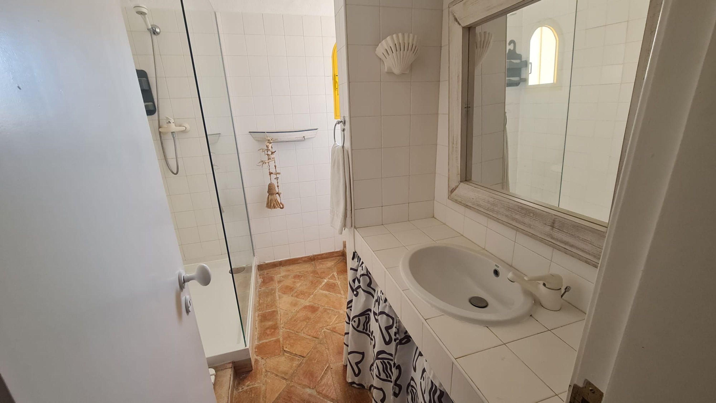 A bathroom with a bathtub, a sink, a mirror, and a shower area.
