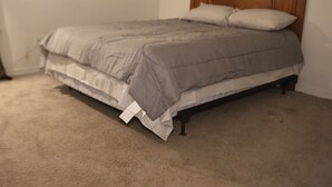 A bedroom with a bed, a wooden headboard, and a carpeted floor. - Home away from home! (Decatur)