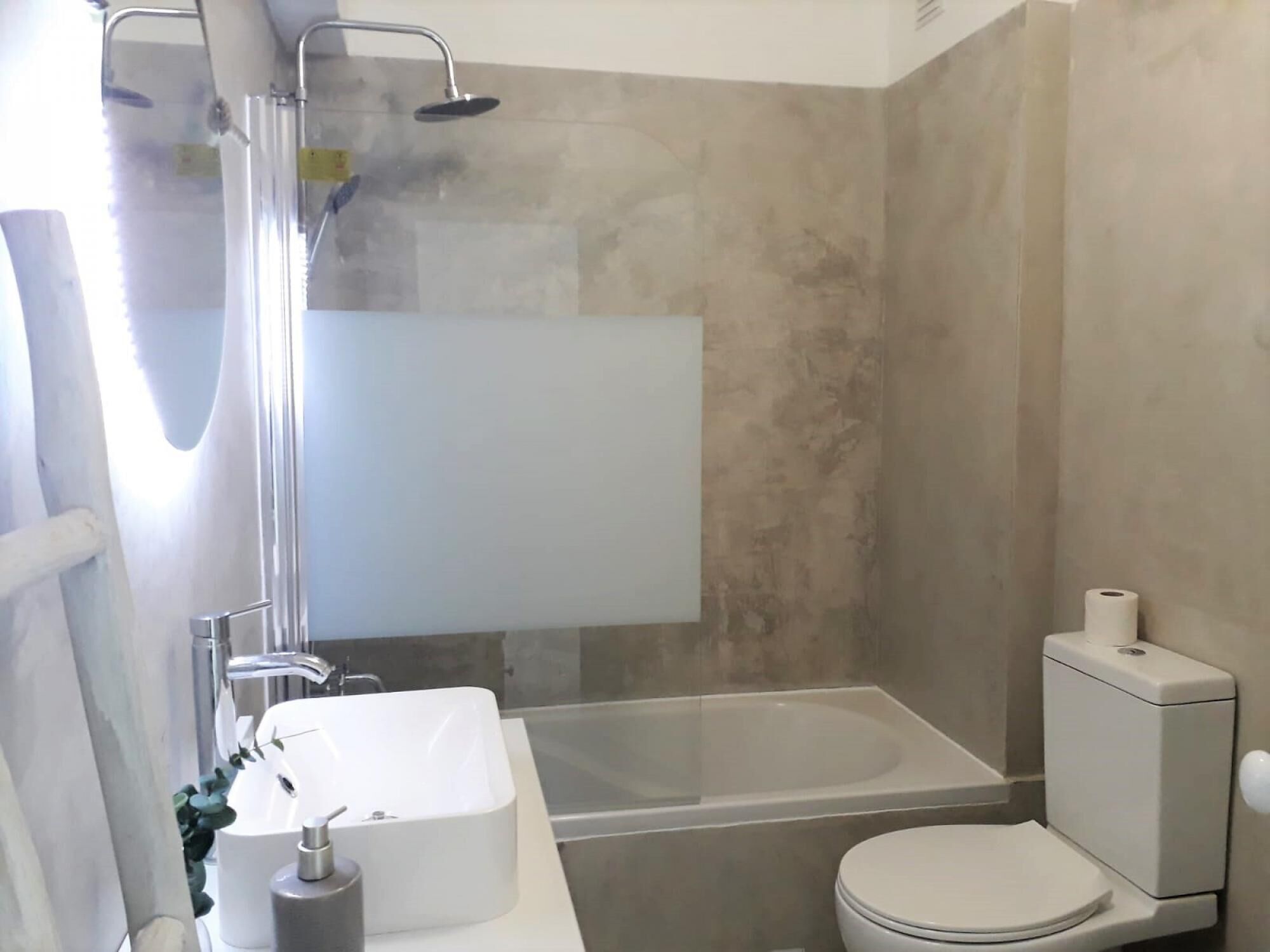 A modern bathroom with a bathtub, toilet, and sink.