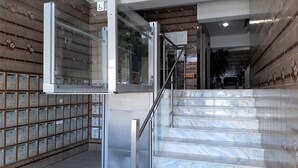 A staircase with marble steps leading to a landing, surrounded by patterned walls and a row of storage boxes. - T1 Torre 20 6G M Gico 80M Praia Wi-fi 4 Pessoas (Loulé)