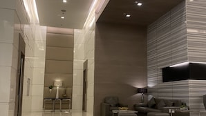 A modern hotel lobby with a spacious layout, a seating area with sofas and a coffee table, and a reception desk. - Jazz Tower A // Cozy Room for 2 Adults //  Best for Short stays (Makati)