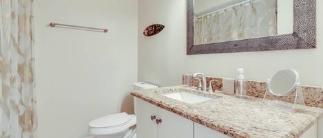 Un baño con inodoro, lavamanos y espejo.