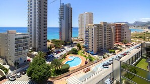 Un hôtel de grande hauteur doté d’une piscine, de plusieurs niveaux de stationnement et offrant une vue sur la mer.