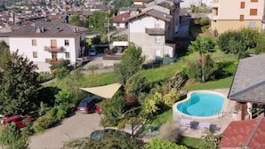 Un quartier résidentiel avec des maisons, une piscine et un paysage montagneux en arrière-plan.