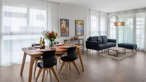 Un salon moderne avec un coin repas, comprenant un canapé, une table basse et une table à manger avec des chaises.