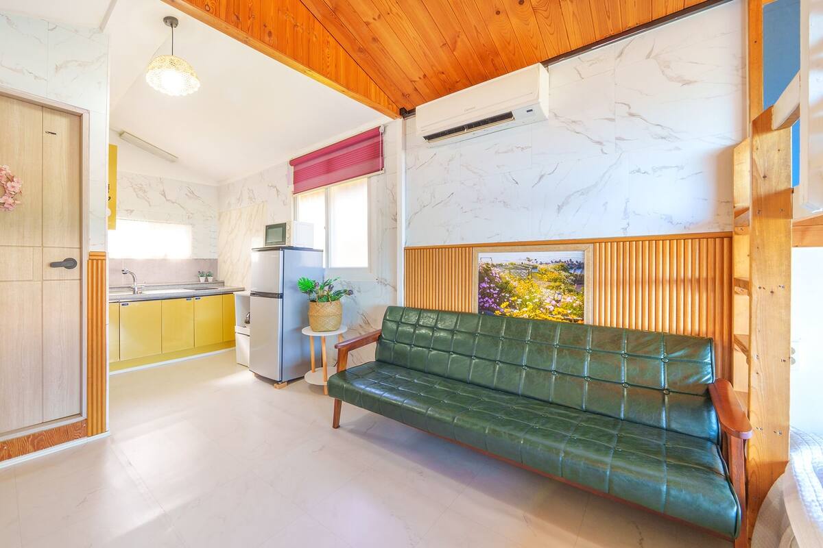 A compact kitchen with a refrigerator, sink, and a small dining area.