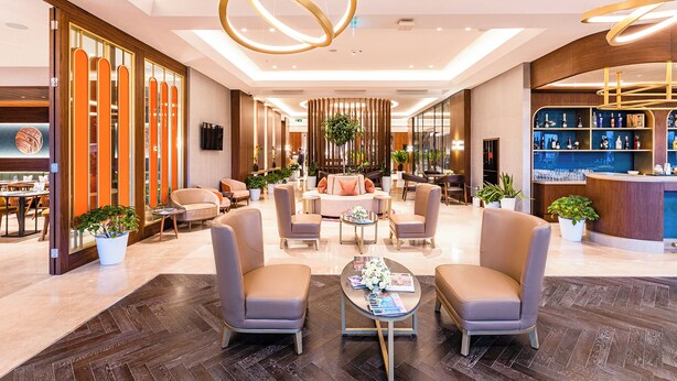 A modern lobby with seating areas, a reception desk, and a bar. - Wellness Park Hotels Turon (Samarkand)