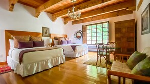 Un dormitorio tipo cabaña de madera con dos camas, una araña y una zona de comedor.