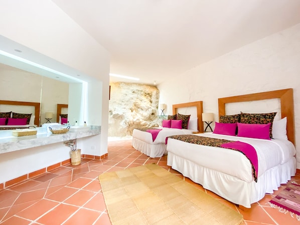 A hotel room with two beds, a large mirror, a stone wall, and a tiled floor. - Molino de los Reyes (Totolac)
