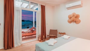 A hotel room with a bed, a chair, a table, and a view of the outside. - MARE MARIN BOUTIQUE HOTEL (Bodrum)