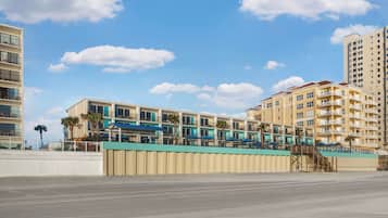 Un hôtel situé en bord de mer, doté de nombreux balcons, d’un espace piscine et offrant une vue sur l’océan.