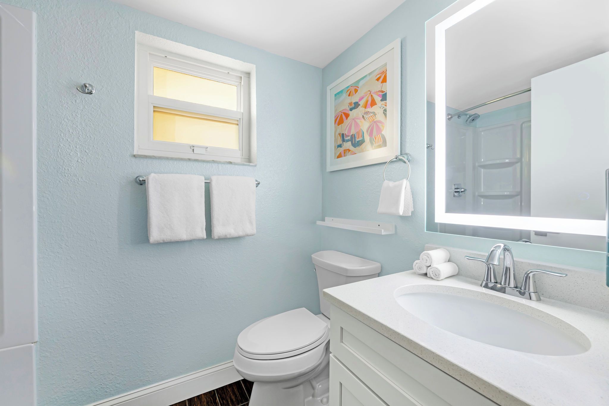 Une salle de bain avec des toilettes, un lavabo et une fenêtre.