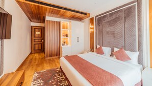A modern hotel room with a large bed, wooden ceiling, and a built-in wardrobe. - The Ramayana Hotel Ayodhya (Faizabad)