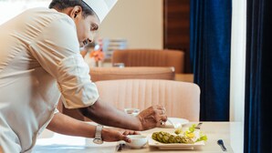 A person dining at a table with a plate of food, a bowl, and a spoon. - The Ramayana Hotel Ayodhya (Faizabad)