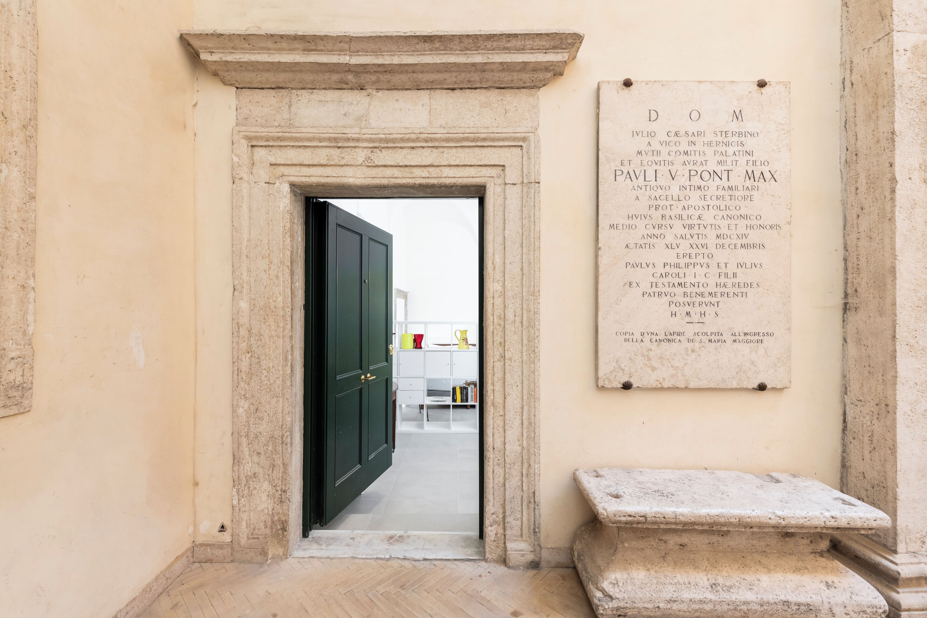 A doorway leading into a room with a plaque on the wall listing names and titles.