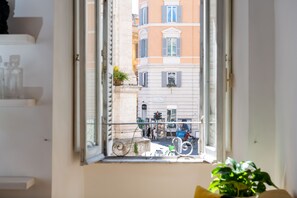 Una ventana con vista a una calle, con edificios y una bicicleta.