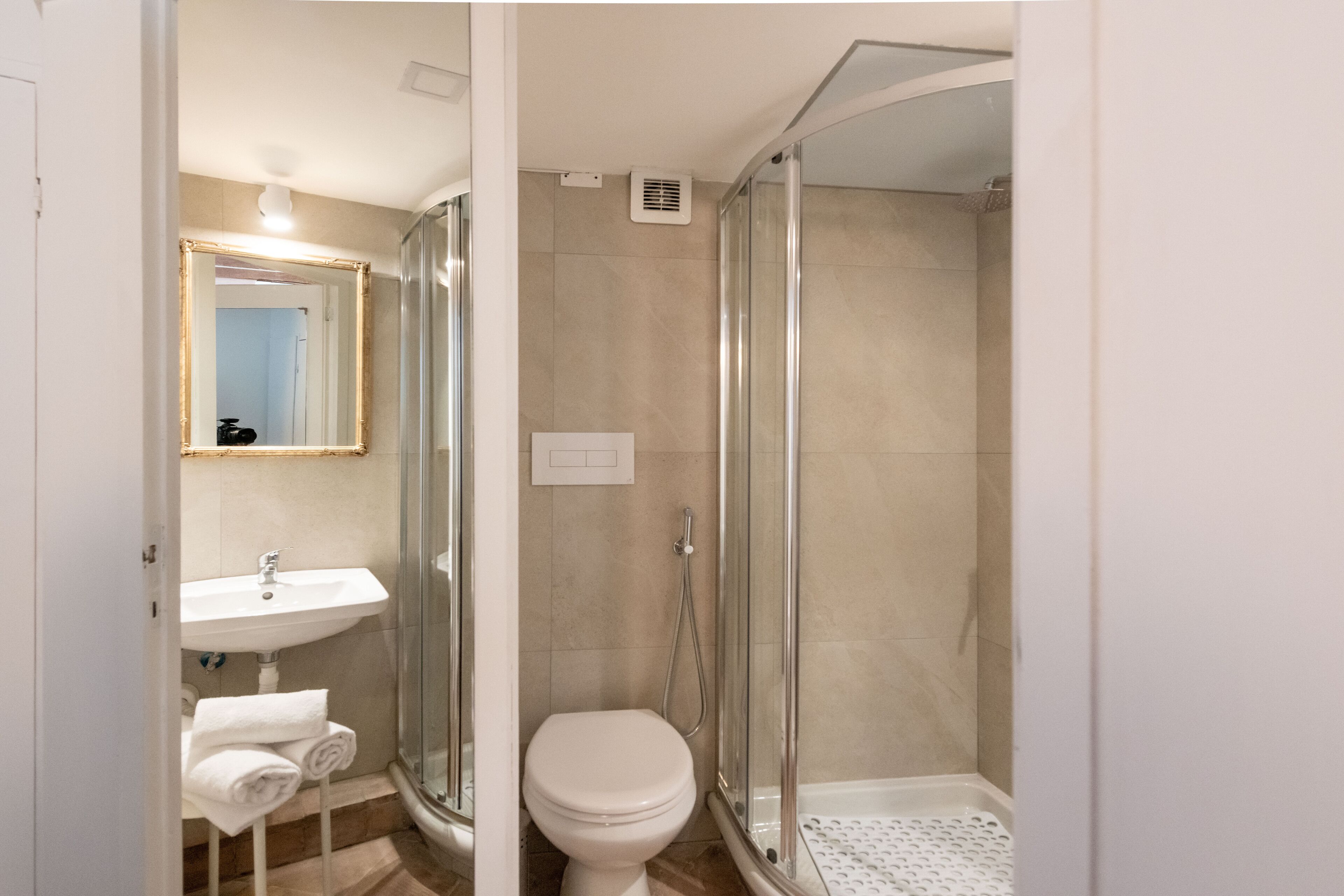 Une salle de bain moderne avec une douche à parois de verre, un lavabo blanc et des toilettes.