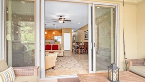 A spacious living area with a sliding glass door leading to a kitchen and dining area. - 2/2 Condo Directly on the Guadalupe River with Beautiful Canyon Views (New Braunfels)