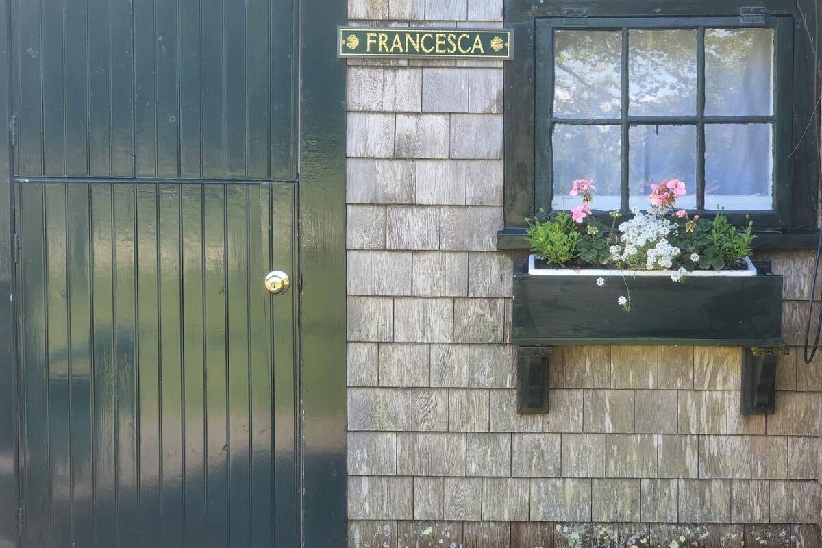 A wooden door with a brass handle and a sign above it reading "FRANCESCA".