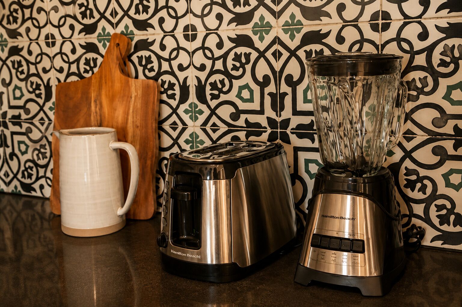 A kitchen counter with a toaster, a blender, and a mug.