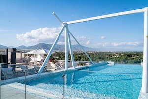 A rooftop pool with a clear view of mountains in the background.