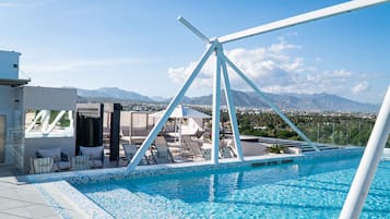Una piscina al aire libre, camas de piscina gratis, sombrillas