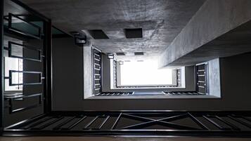 Een moderne architecturale ruimte met betonnen plafonds, metalen hekwerk en dakramen.